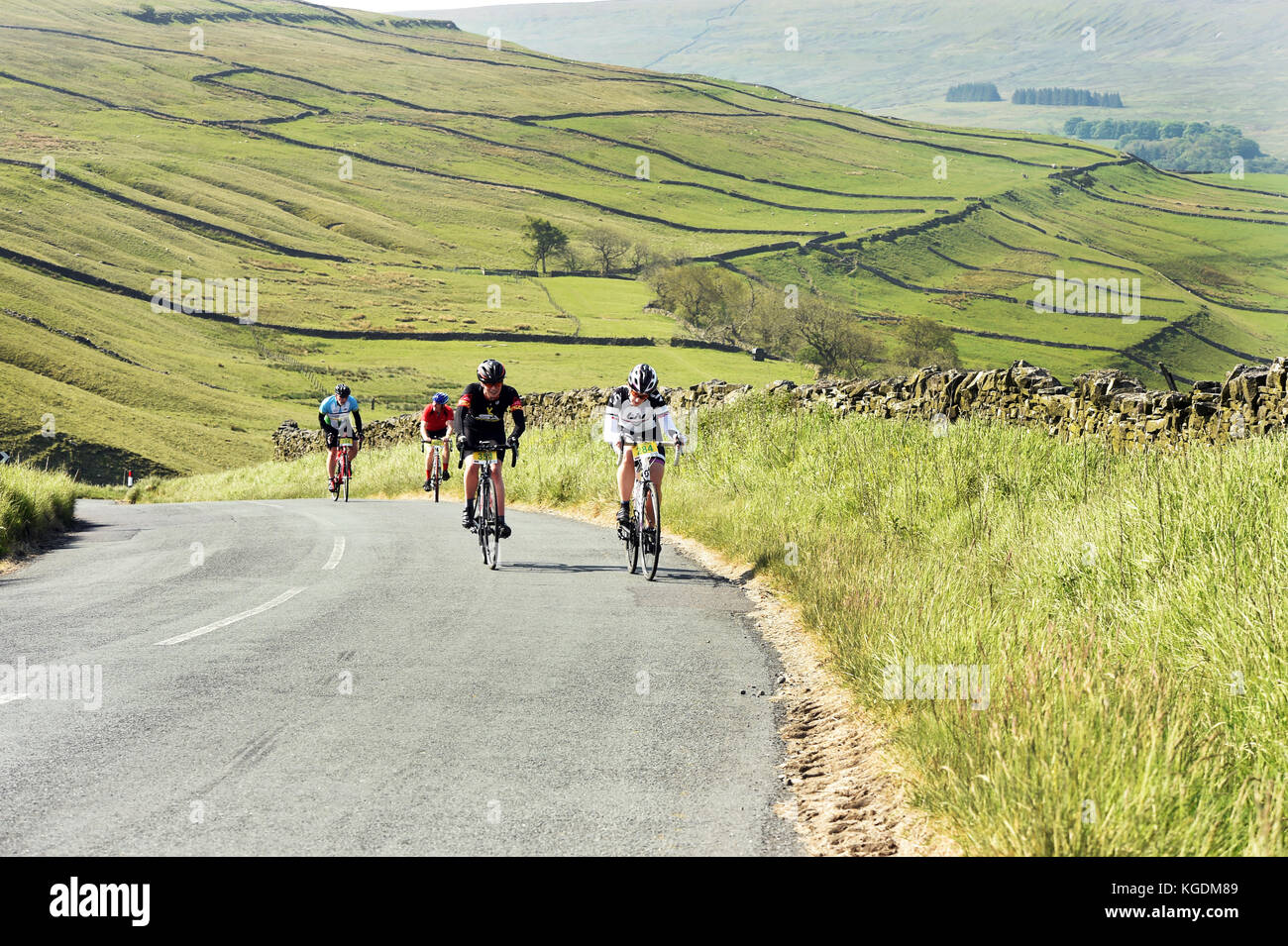 I ciclisti andare in bicicletta nelle valli dello Yorkshire Regno Unito viaggiando attraverso il bellissimo paesaggio vicino a Settle Foto Stock