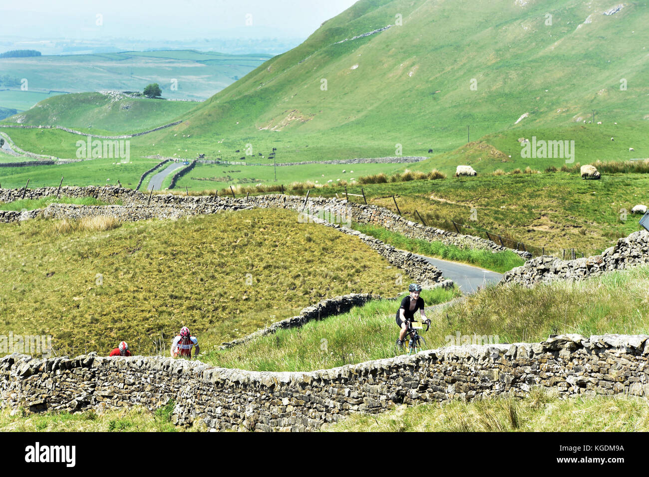 I ciclisti andare in bicicletta nelle valli dello Yorkshire Regno Unito viaggiando attraverso il bellissimo paesaggio vicino a Settle Foto Stock