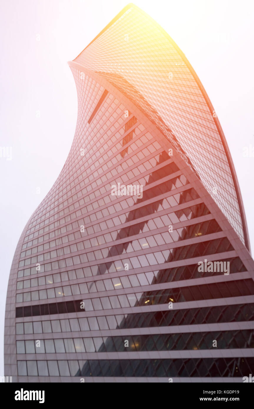 Moderno edificio di vetro centro business. grattacielo in città. i raggi del sole si riflettono nella superficie di vetro dell'edificio. vista dal basso Foto Stock