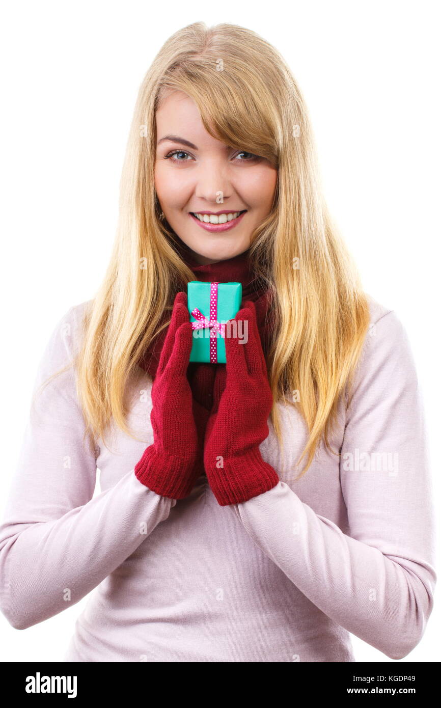 Donna sorridente in guanti di lana azienda dono avvolto con nastro per natale, Valentino, compleanno o altra celebrazione, sfondo bianco Foto Stock