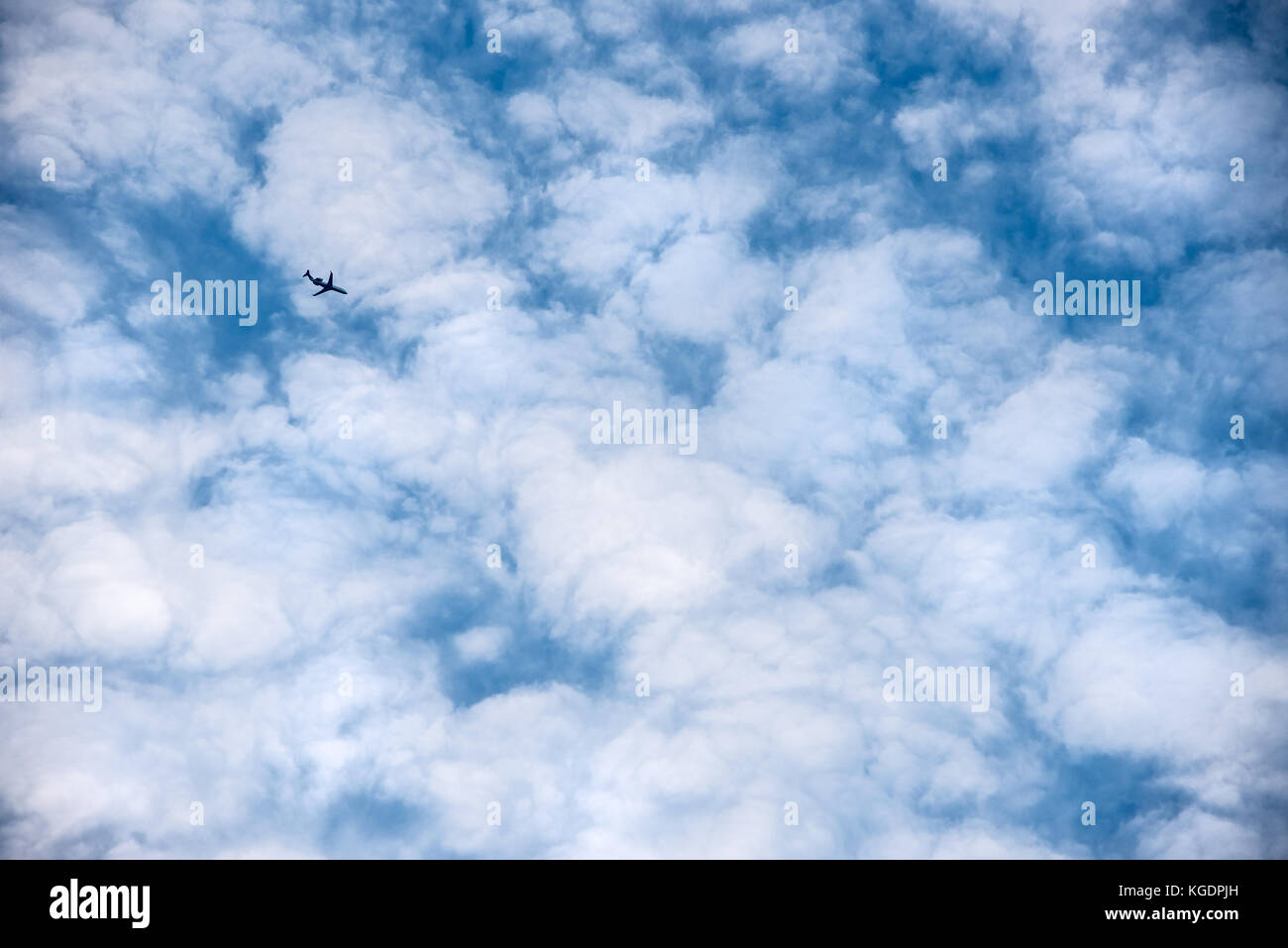 Linea aerea passeggeri jet che volando contro uno sfondo bianco di nuvole puffy somigliante a palline di cotone. (USA) Foto Stock