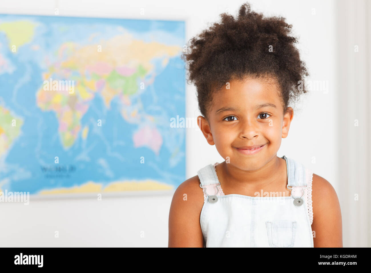Americano africano ragazza in età prescolare in aula con mappa del mondo Foto Stock