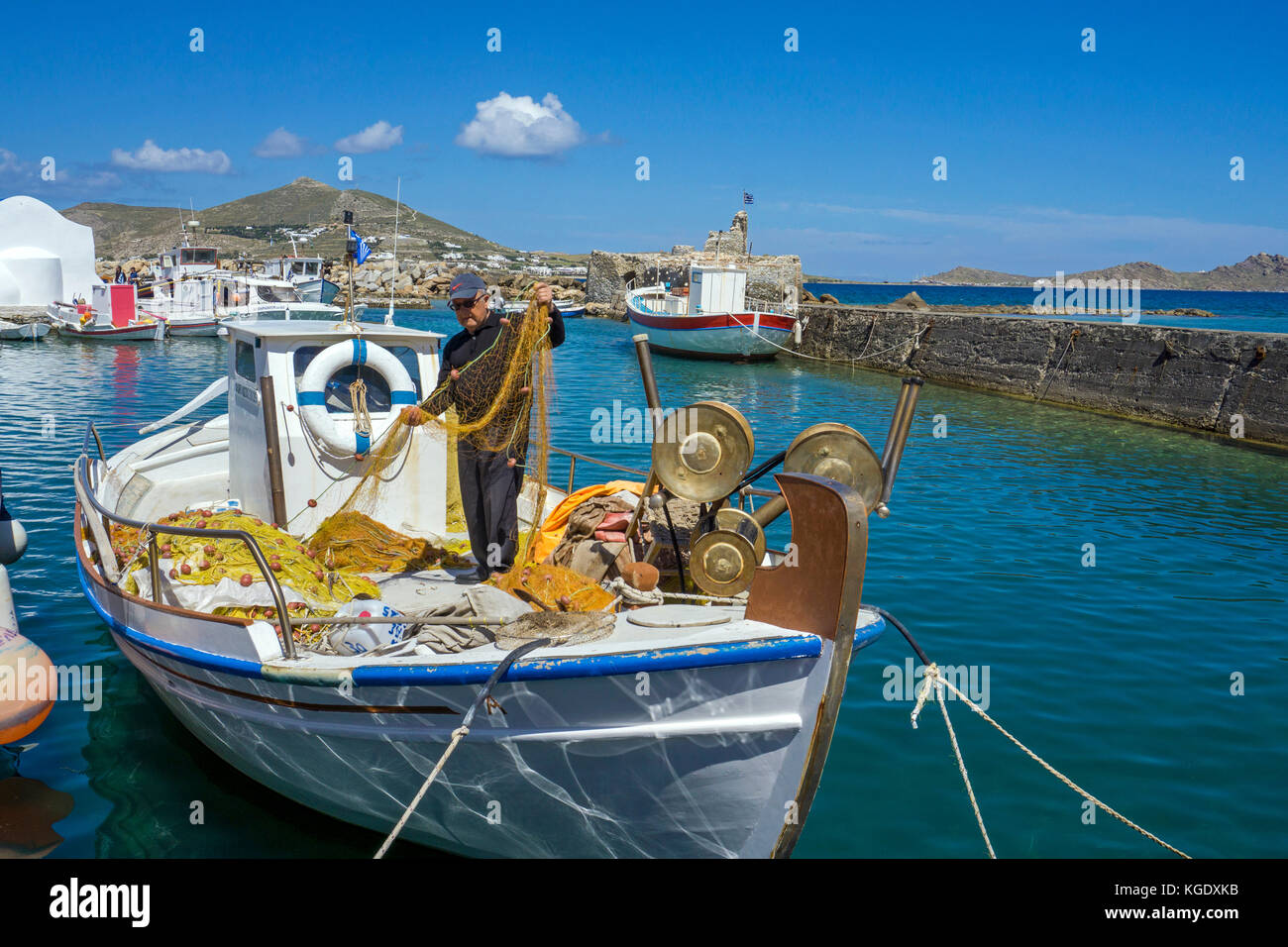 Fisherman controlla il suo netto a porto di Naoussa, isola di Paros, Cicladi, Egeo, Grecia Foto Stock