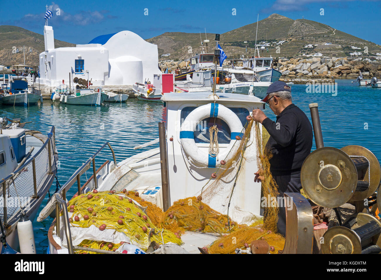 Fisherman controlla il suo netto a porto di Naoussa, isola di Paros, Cicladi, Egeo, Grecia Foto Stock