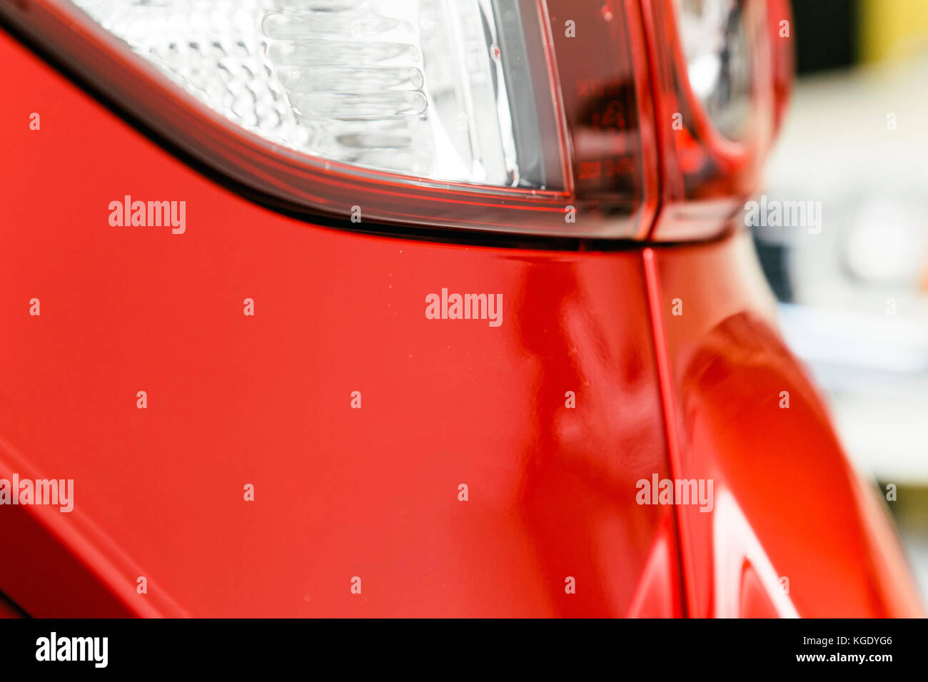 Auto closeup con luci di coda, indicatori, lampeggiatori e indicatori di direzione. rosso vernice lucida di un nuovissimo auto paraurti del veicolo. Foto Stock