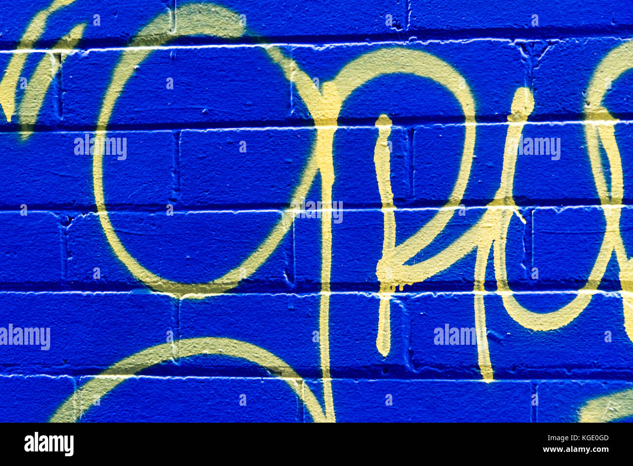 Grunge di mattoni di colore blu su sfondo giallo astratto modello. strada urbana arte parete texture, giallo marcatura corsive dipinta sul blu. Foto Stock