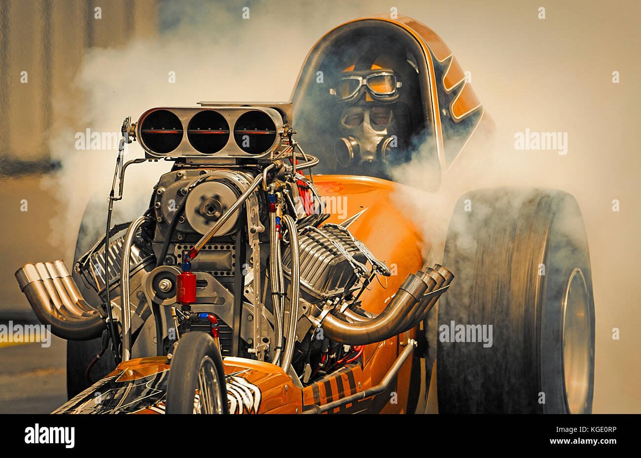 Jon Webster esegue un burnout nel suo slingshot dragster a Santa Pod Raceway Foto Stock