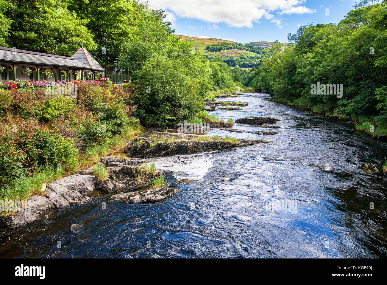 Fiume Dee vicino a Berwyn, Wales, Regno Unito. Fiume nella valle circondata da alberi con collina in background. Bella giornata d'estate. Foto Stock