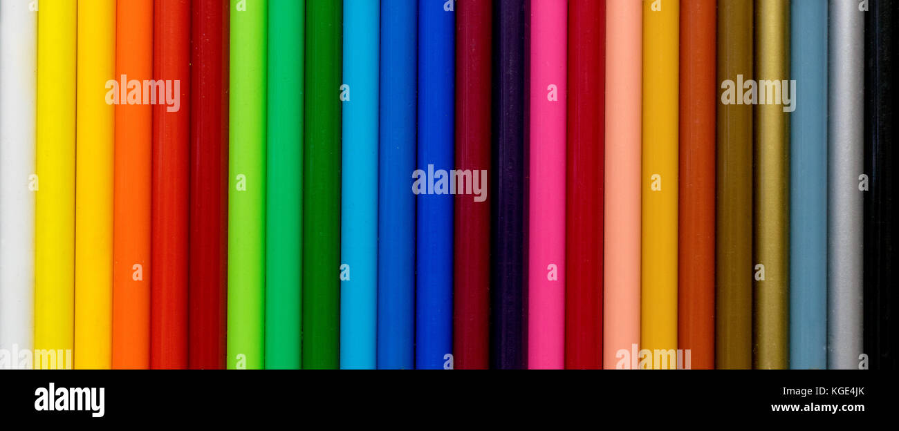 Colorate matite colorate allineate su un gradiente arcobaleno closeup pattern e texture. Foto Stock