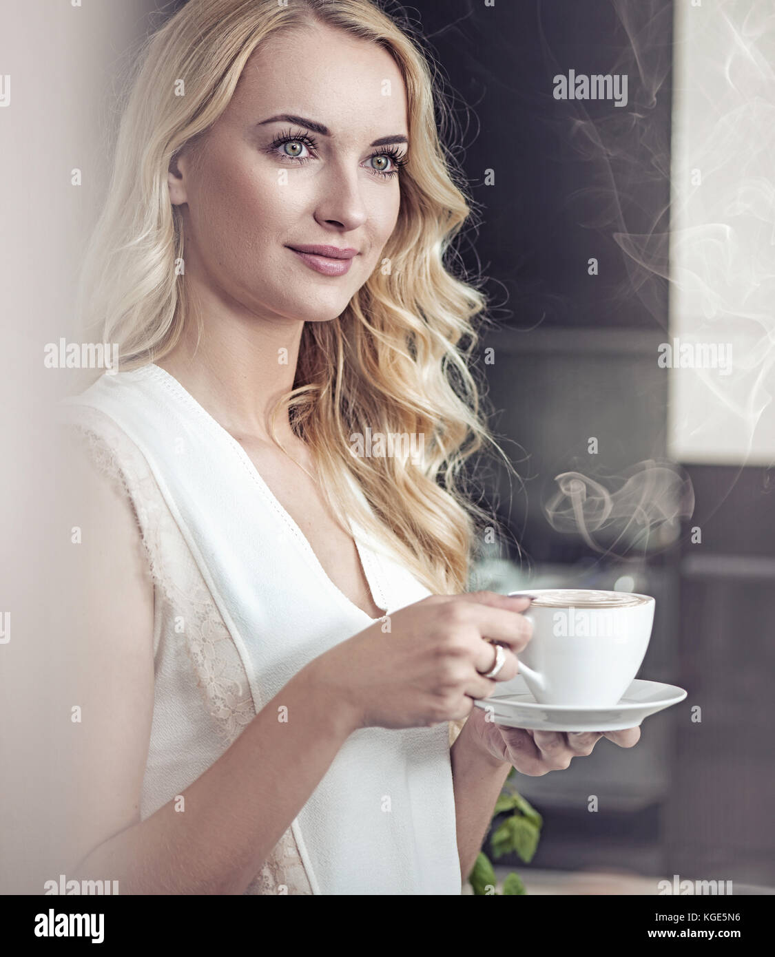 Ritratto di una bella bionda signora bevendo una tazza di caffè Foto Stock