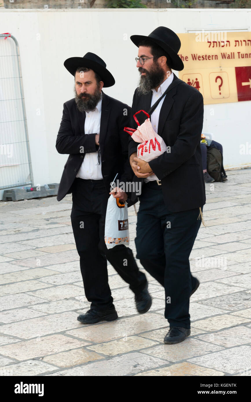 Israele la Terra Santa Gerusalemme Città Vecchia portava religiosi ebrei  assidici uomini ebrei neri vestiti cappelli camminare accanto al muro  occidentale portando borse di plastica Foto stock - Alamy