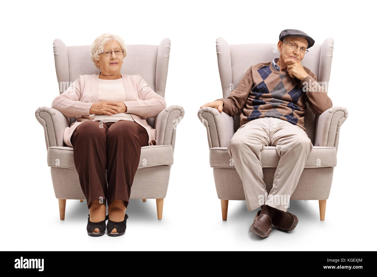 Uomo anziano e una donna anziana seduti in poltrona e guardando la telecamera isolata su sfondo bianco Foto Stock