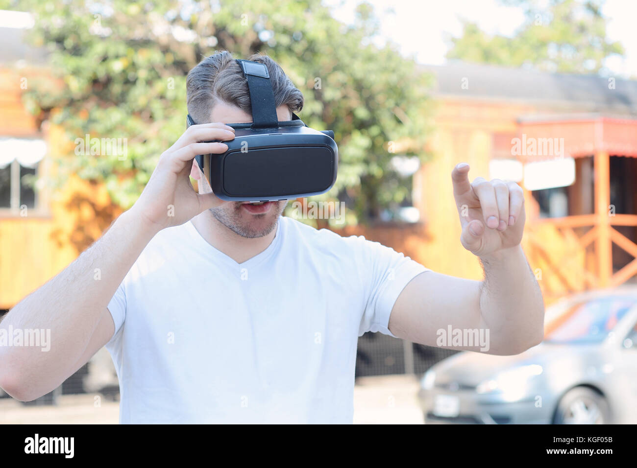 Giovane uomo utilizzando occhiali per realtà virtuale all'esterno. Foto Stock