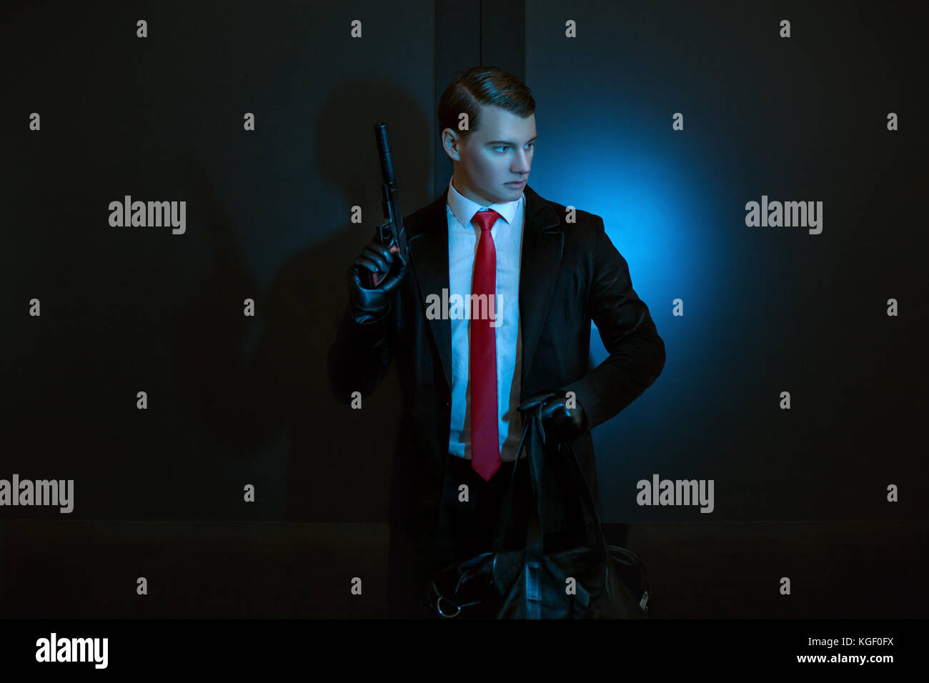 L uomo è un assassino con una pistola in mano di notte. Foto Stock