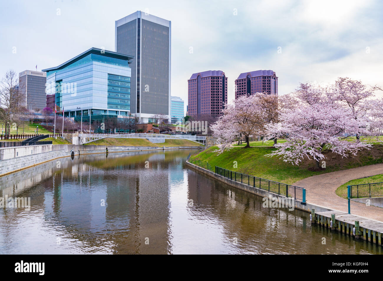 Richmond, Virginia, skyline mattutino della città lungo il fiume James vicino a Brown's Island e Tredegar St durante la fioritura dei ciliegi. Foto Stock