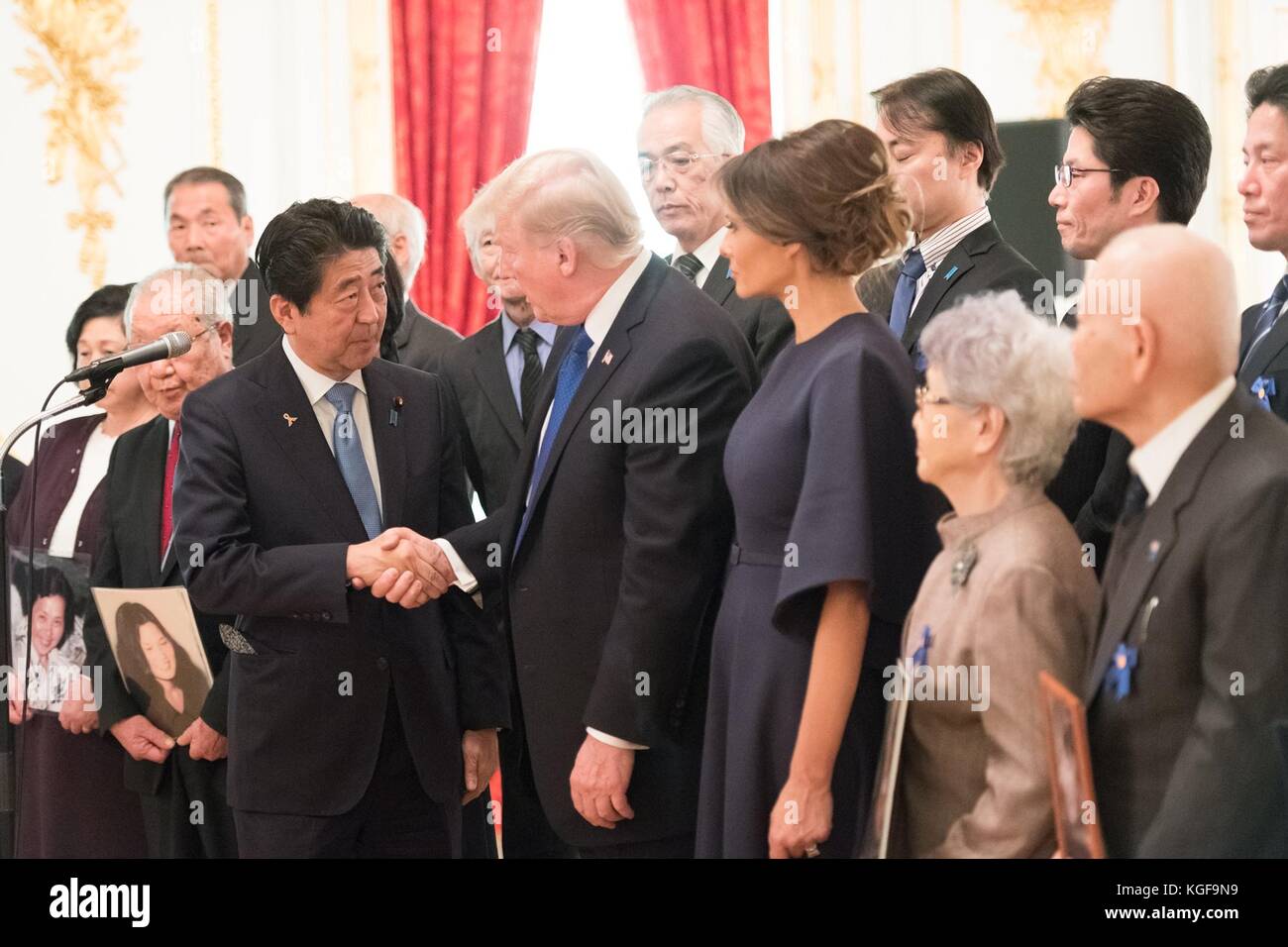 U. Il presidente Donald Trump stringe la mano al primo ministro giapponese Shinzo Abe mentre la first lady Melania Trump guarda durante un incontro con familiari di cittadini giapponesi rapiti dalla Corea del Nord presso la pensione statale del Palazzo Akasaka il 6 novembre 2017 a Tokyo, Giappone. Trump è in visita di tre giorni in Giappone, la prima tappa di un volo di 13 giorni attraverso l'Asia. Foto Stock