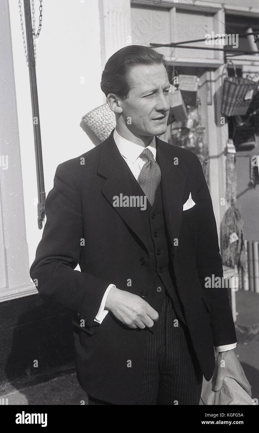 1955, Inghilterra, una dapper, ben vestito British uomo in piedi fuori indossando una tre-pezzo tuta. Foto Stock
