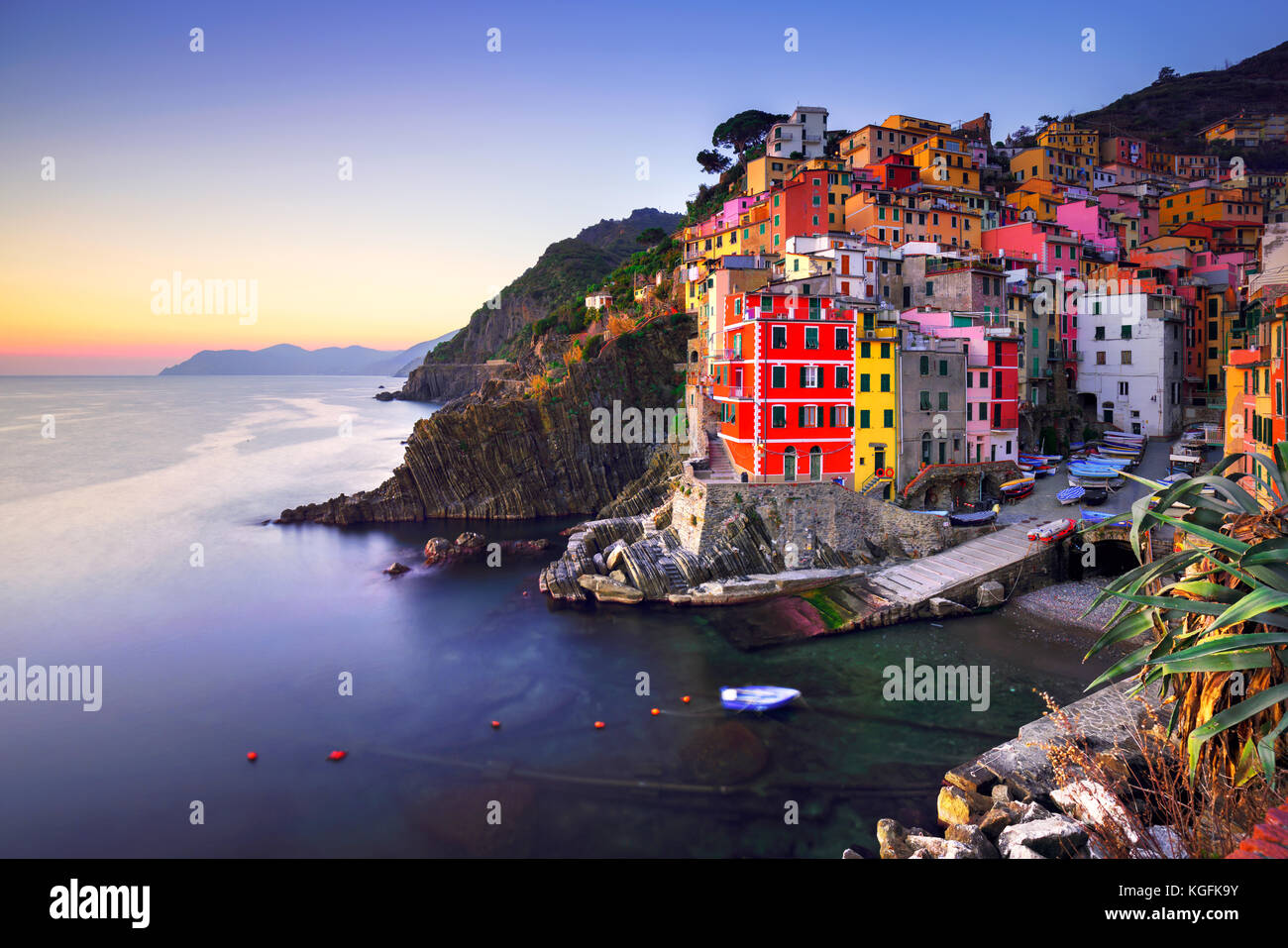 Riomaggiore villaggio sulla scogliera di rocce e mare al tramonto., Seascape in cinque terre, il Parco Nazionale delle Cinque Terre Liguria Italia Europa. Esposizione lunga Foto Stock