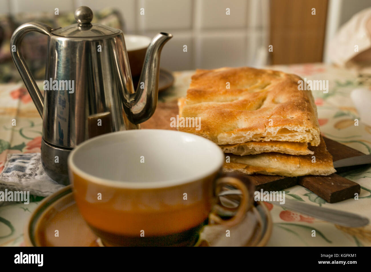 Colazione a Genova, Italia. Un modo tradizionale per iniziare la giornata. Focaccia croccante con un caffè espresso sul tavolo della cucina di nonna Foto Stock