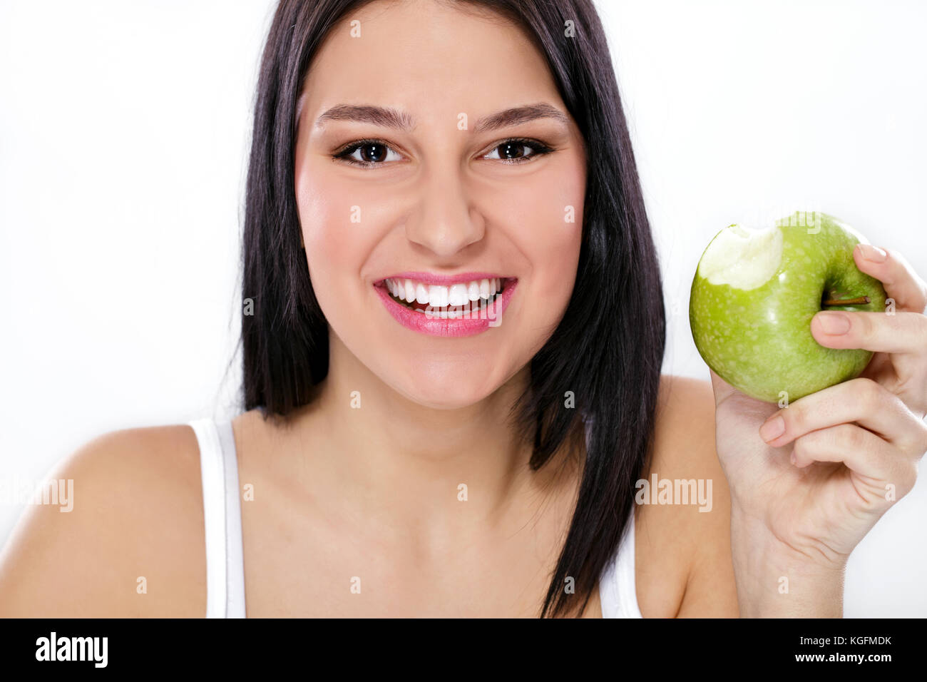 Felice giovane donna azienda verde mela con morso mancante Foto Stock