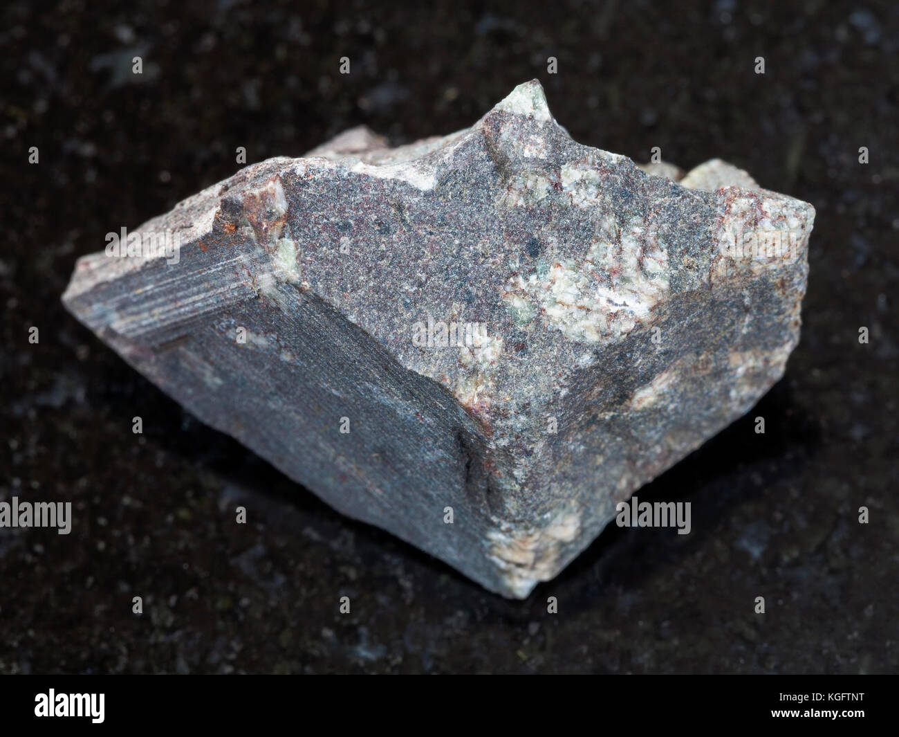 Le riprese in modalità macro di minerale naturale campione di roccia - porphyritic ruvida in pietra basaltica sul granito scuro dello sfondo Foto Stock