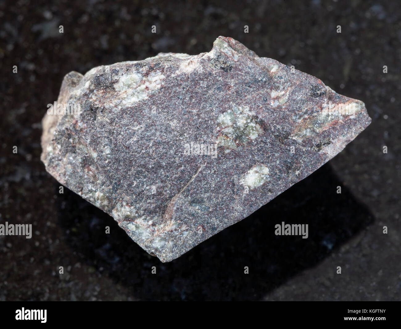 Le riprese in modalità macro di minerale naturale campione di roccia - materie porphyritic basalto sulla pietra di granito scuro dello sfondo Foto Stock