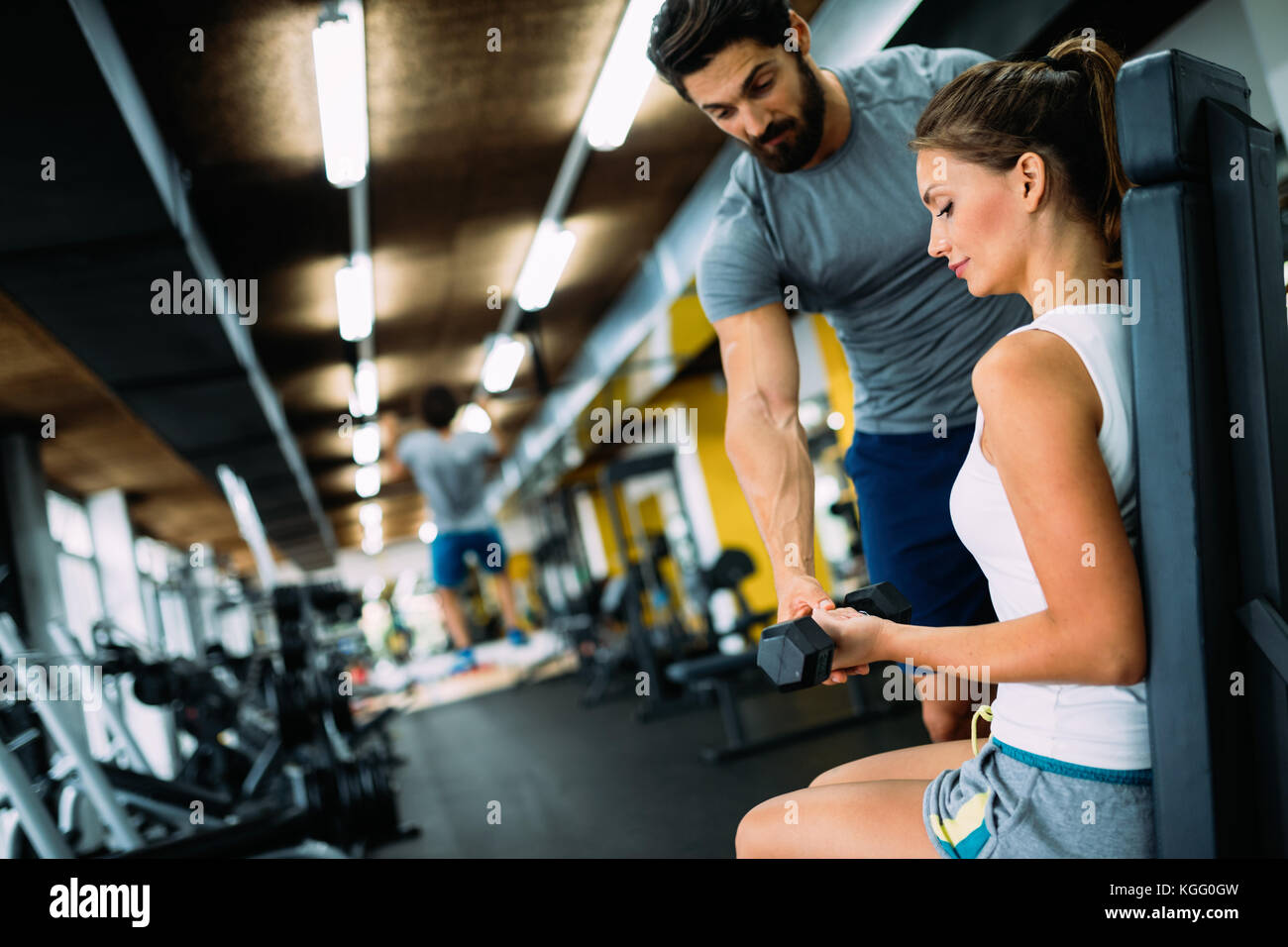 Giovane bella donna facendo esercizi con personal trainer Foto Stock