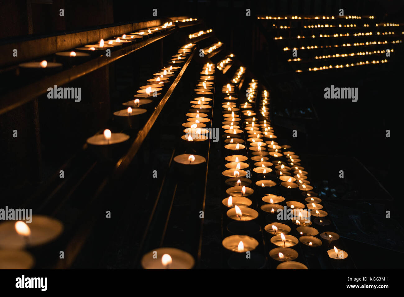 Molte candele accese in una chiesa. Foto Stock