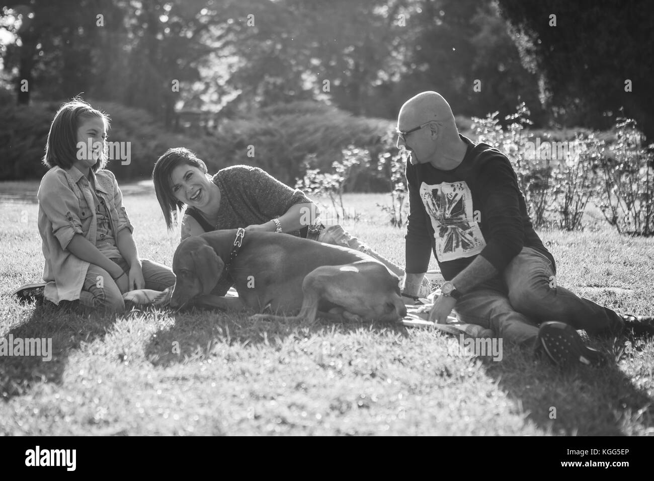 Immagine in bianco e nero di famiglia felice di tre giocando in pa Foto Stock