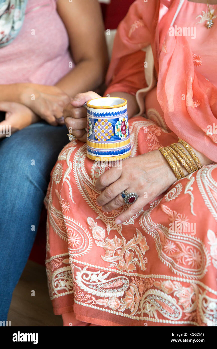 Donna indiana in sari holding mug Foto Stock