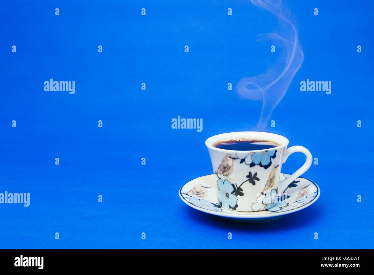 Tazza blu con caffè a vapore. Fumo morbido. Sfondo blu. Foto orizzontale Foto Stock