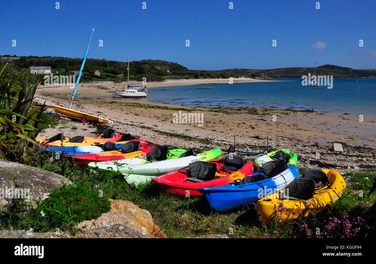 Canoe dai colori vivaci sulla spiaggia di Bryer in attesa della marea di entrare e visitatori di usare them.Isles di Scilly, Cornovaglia, Regno Unito. Foto Stock