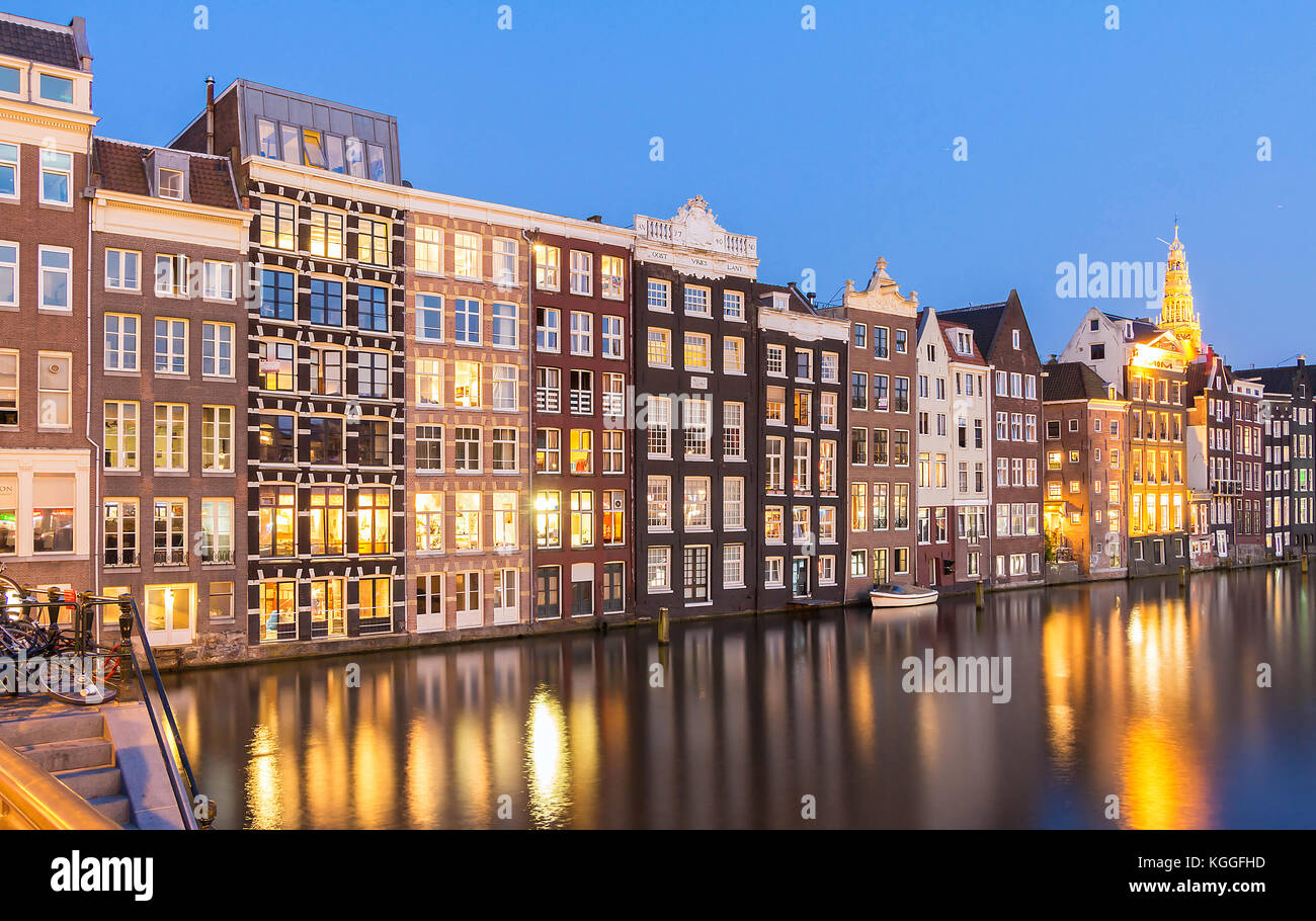 Case facciate sul canale con riflessi illuminati di notte, Amsterdam. Foto Stock