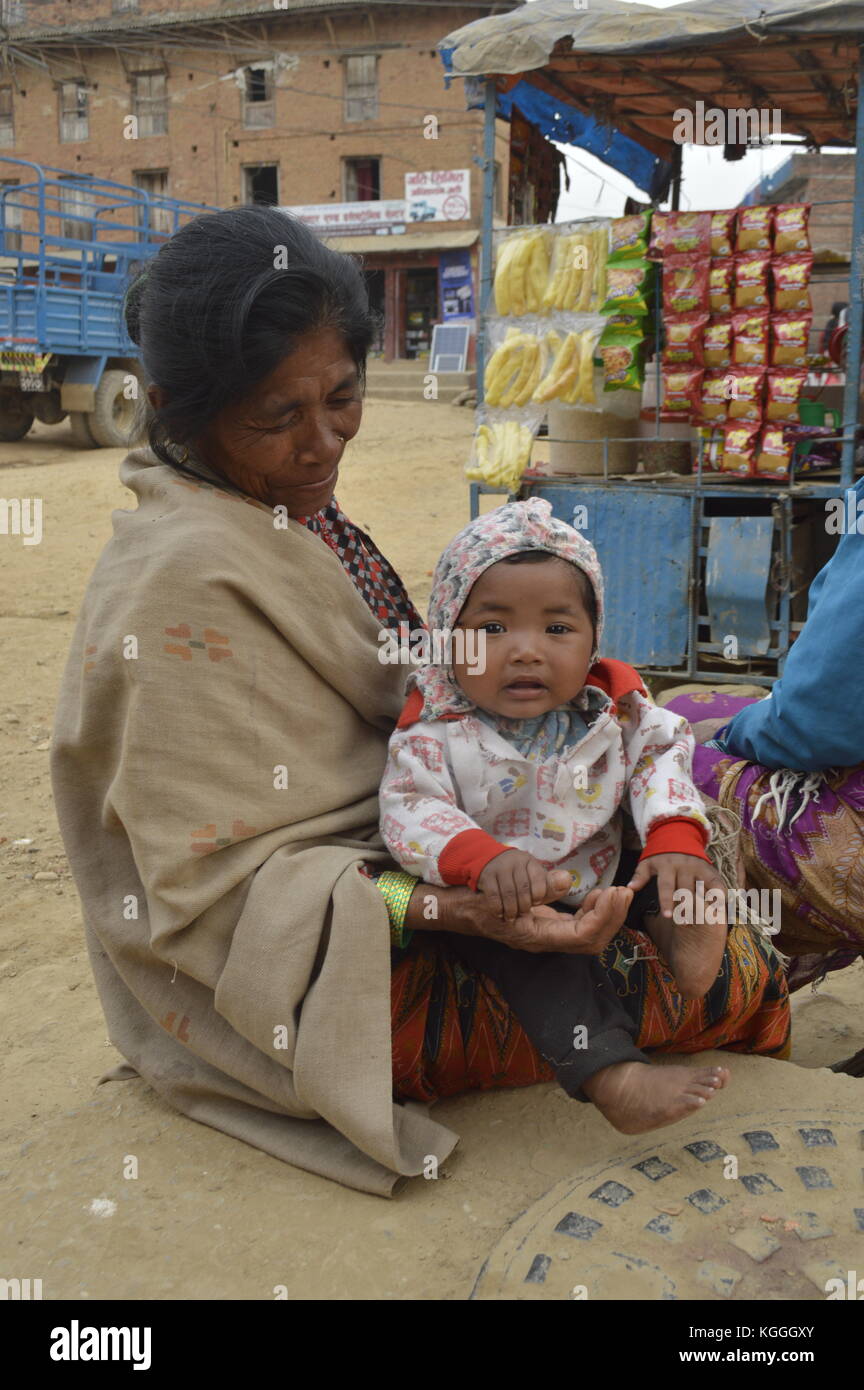 Vecchia nonna nepalese con nipote in grembo. tenendo mani e piedi. A Panauti, Nepal. bambino. bei occhi marroni. Foto Stock