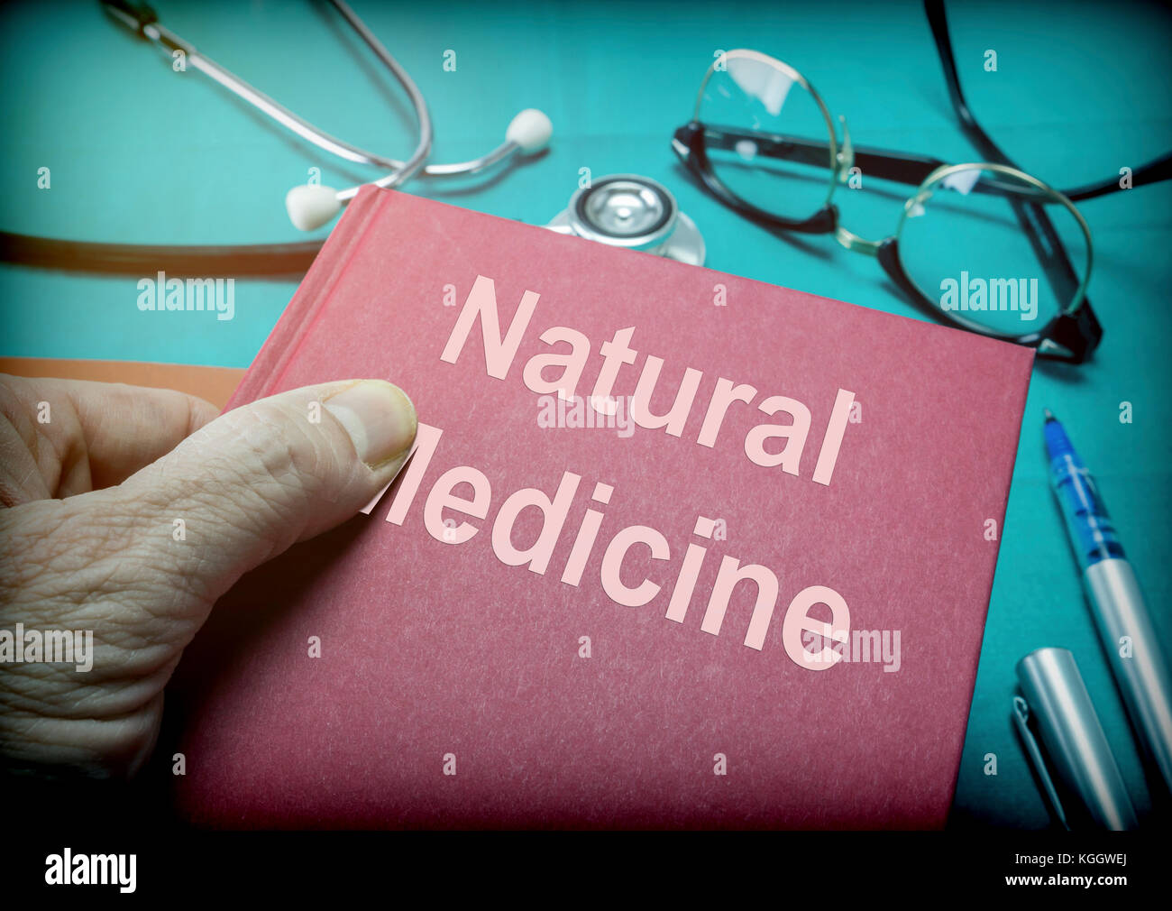 Medico supporta un libro di medicina naturale in un laboratorio di analisi mediche Foto Stock