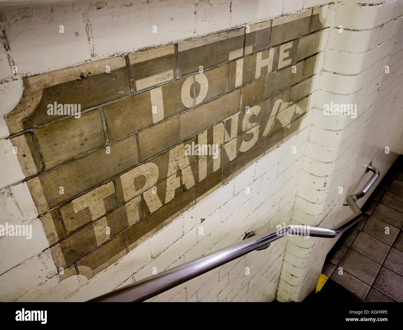 Cartello edoardiano London Undeground sul muro delle scale che conducono ai binari della stazione Stepney Green nell'East End di Londra. Foto Stock