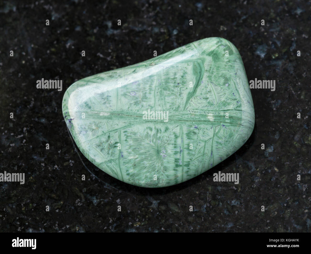 Le riprese in modalità macro di minerale naturale campione di roccia - burattati tinguaite gemma sul granito scuro lo sfondo da monti khibiny, penisola di Kola, Russia Foto Stock