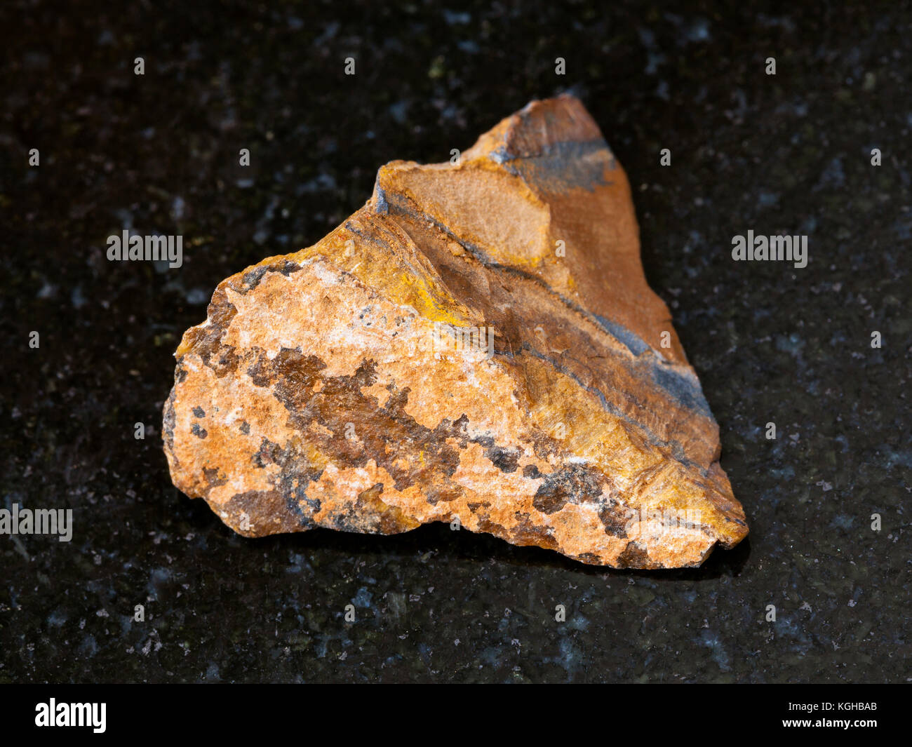 Le riprese in modalità macro di minerale naturale campione di roccia - materie occhio di tigre sulla pietra di granito scuro sfondo dal sud africa Foto Stock