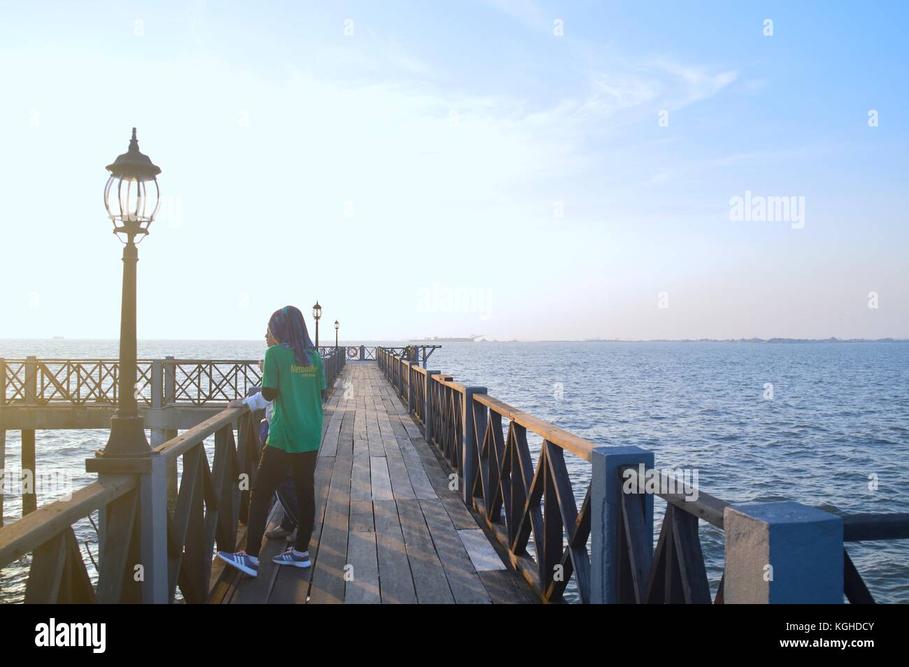 Belle ragazze presso il molo di attesa per la mattina ray Foto Stock