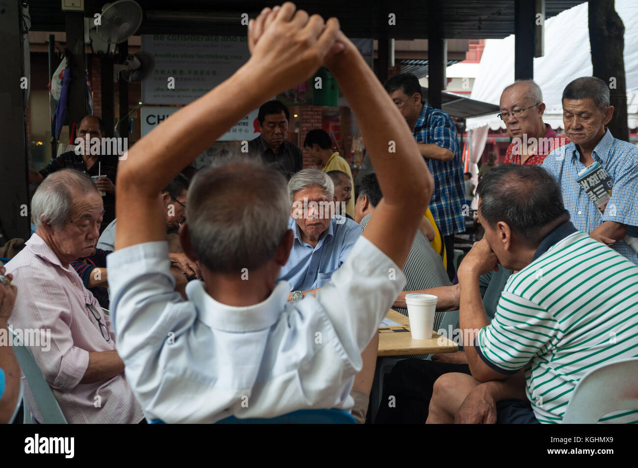 03.11.2017, Singapore, Repubblica di Singapore, in Asia - uomini anziani seguire una partita di scacchi cinesi in una pubblica piazza a Chinatown. Foto Stock