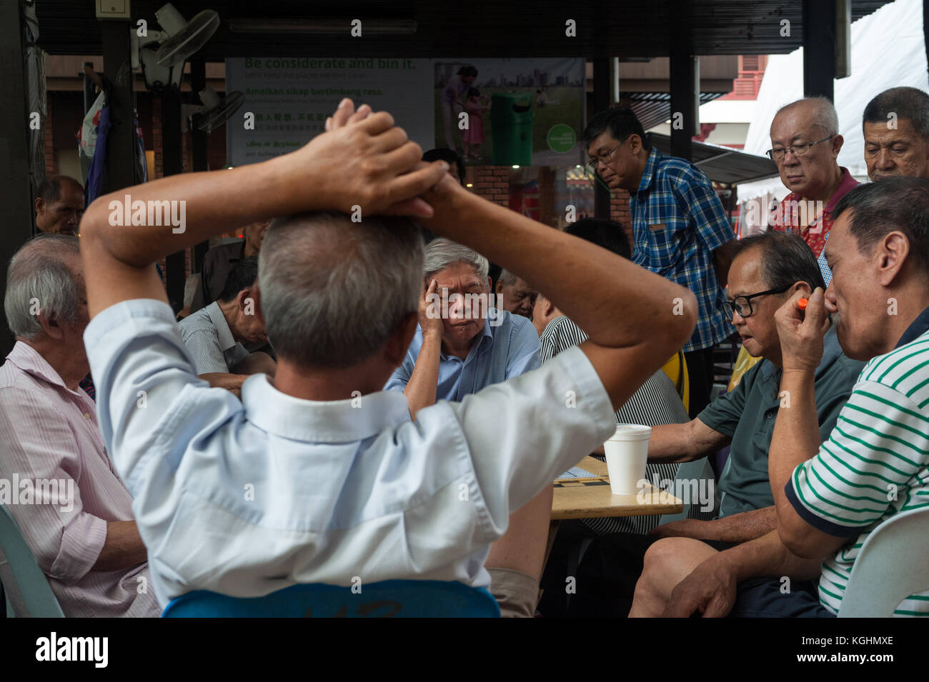 03.11.2017, Singapore, Repubblica di Singapore, in Asia - uomini anziani seguire una partita di scacchi cinesi in una pubblica piazza a Chinatown. Foto Stock