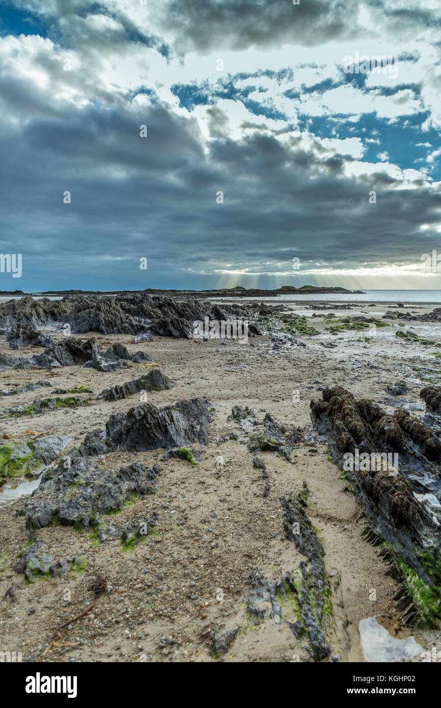 Raggi di sole all'orizzonte presso la spiaggia cittadina, rhosneigr su anglesey Foto Stock