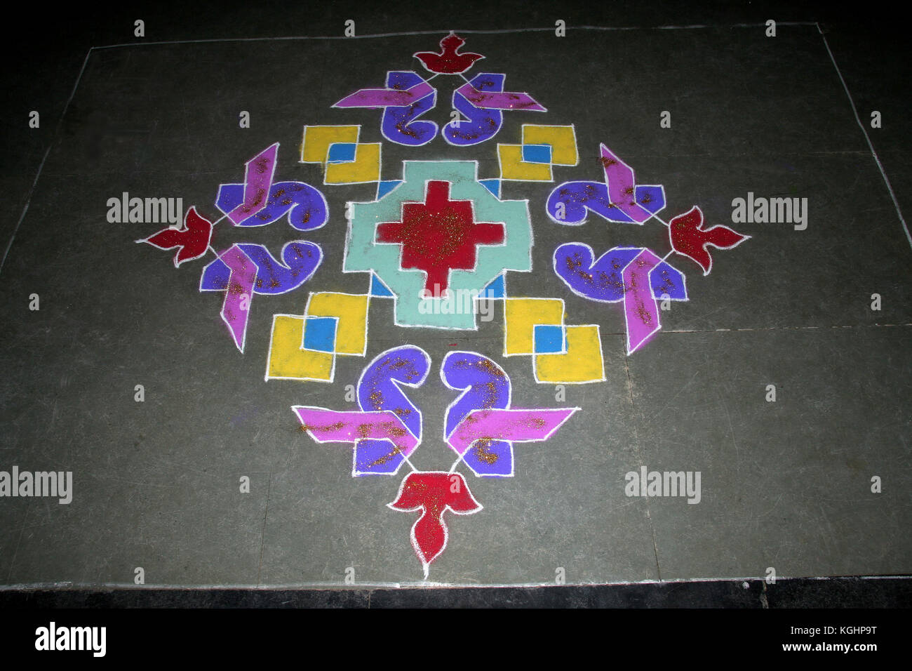 Creazione di coloratissimi pattern geometrico in rangoli arte usando pietra polvere miscelata con i colori Foto Stock
