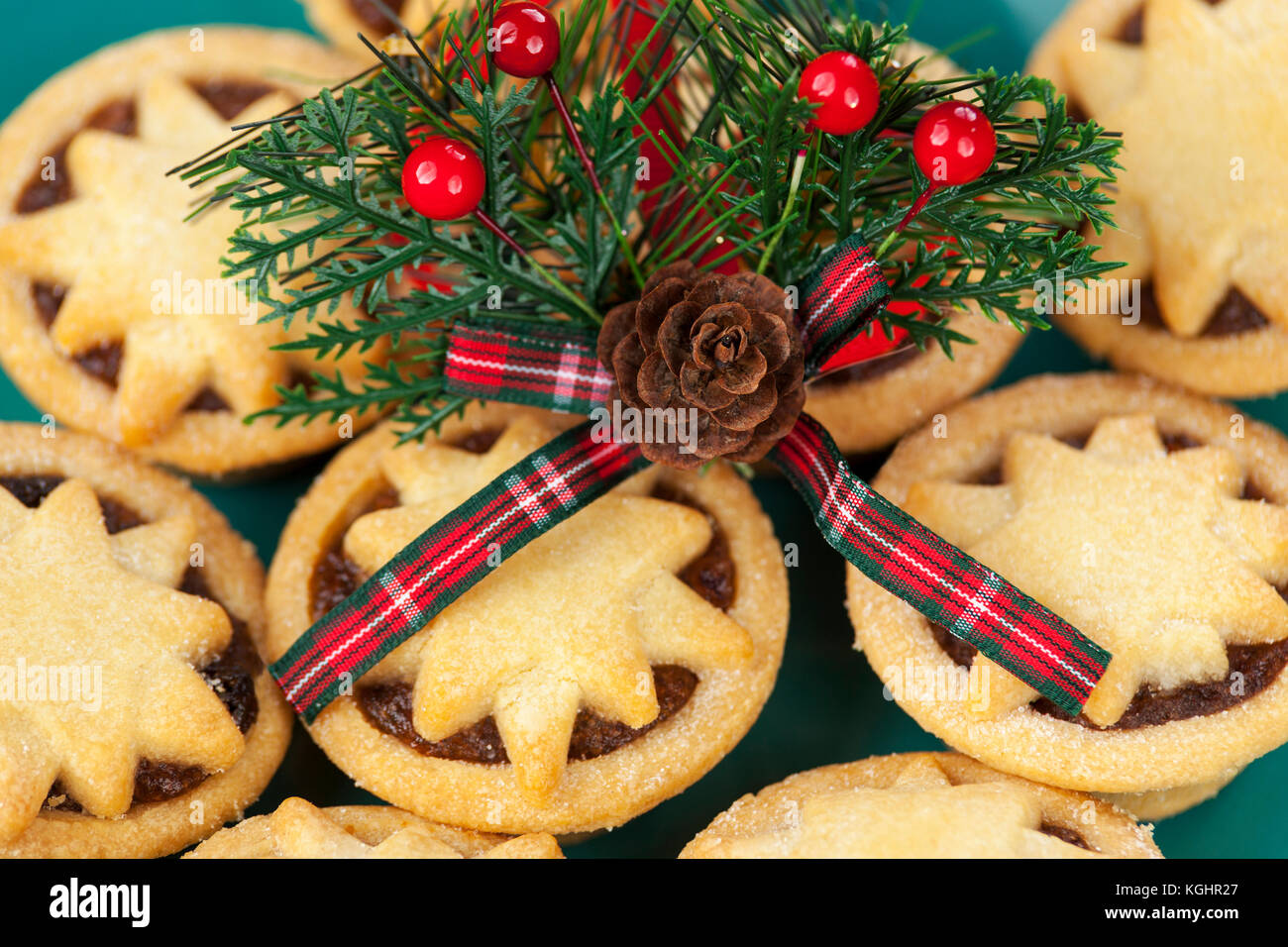 Natale acorn e motivo di tartan con bacche sulla parte superiore di una piastra di pane appena sfornato star sormontato pasticci di carne macinata Foto Stock