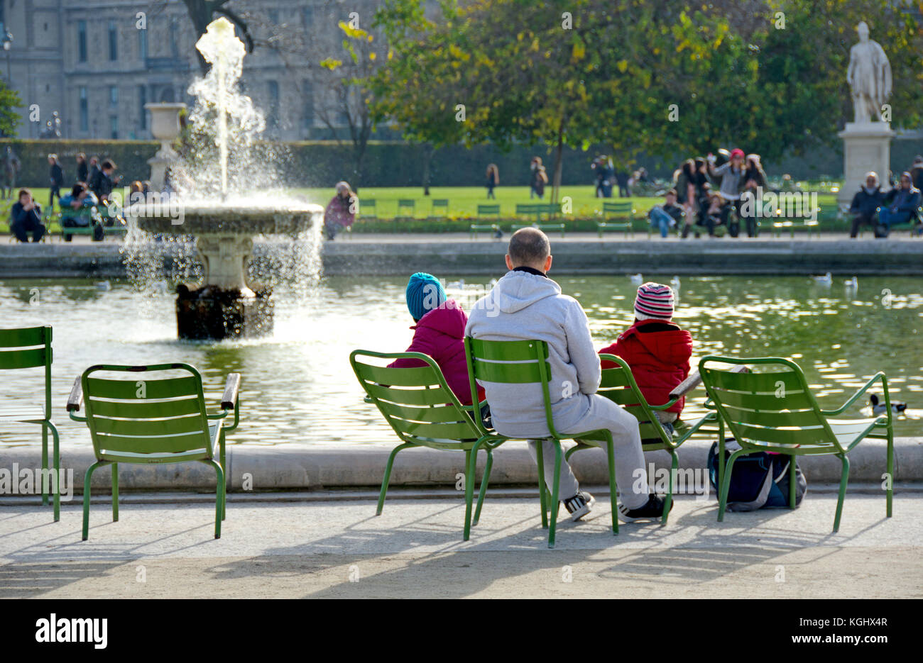 Parigi, Francia. Jardin des Tuileries. Uomo con la sua giovane famiglia vicino al Bassin Ottagonal (stagno) Foto Stock