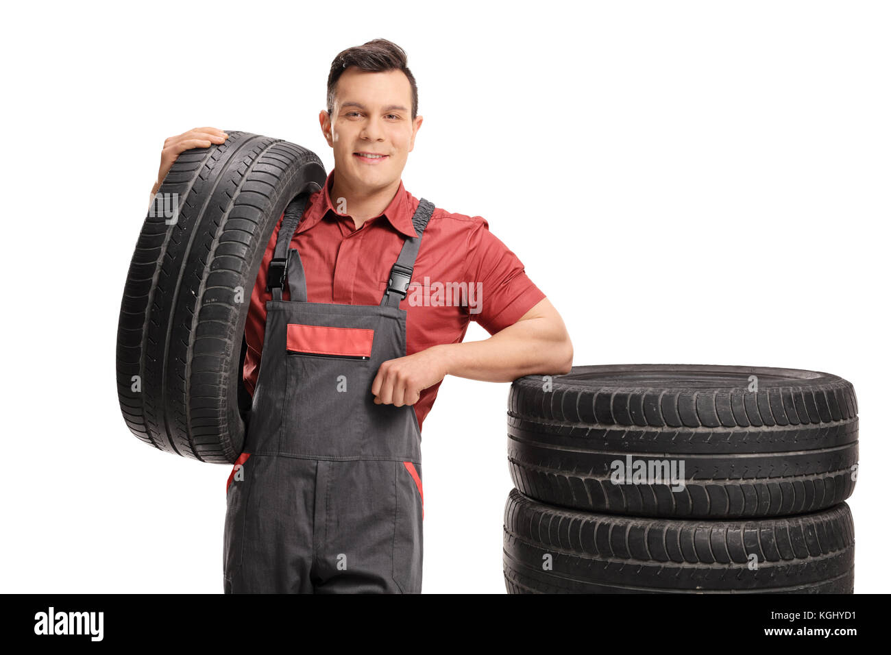 Mechanic appoggiato su una pila di gomme isolati su sfondo bianco Foto Stock