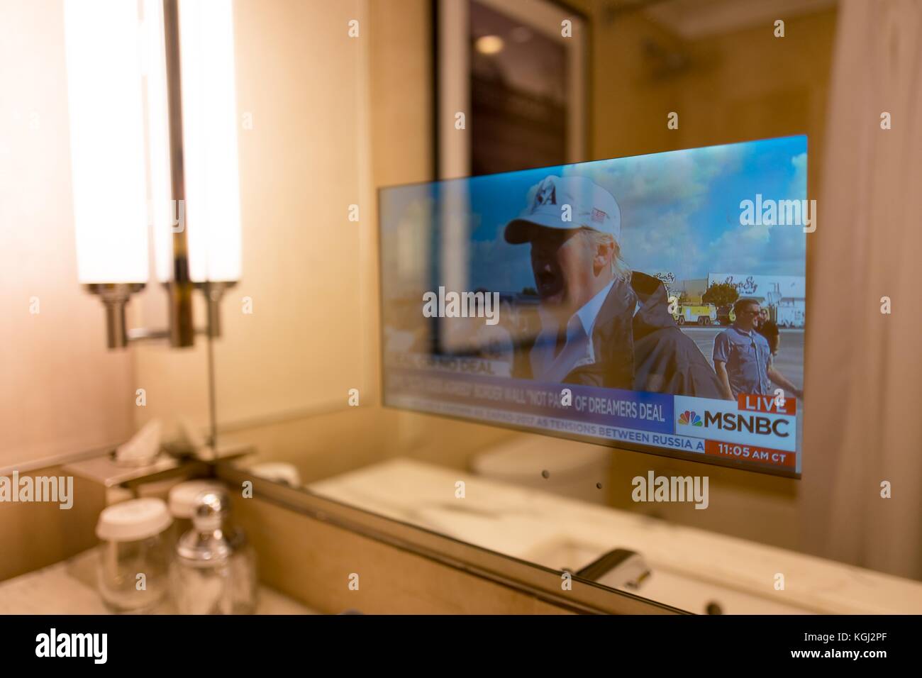 In un business hotel a Manhattan, new york New York, una televisione trasparente incorporato nello specchio del bagno fornisce le ultime notizie e gli aggiornamenti per gli ospiti dell'albergo, in questo caso una storia circa il presidente statunitense Donald Trump, 14 settembre 2017. Foto Stock