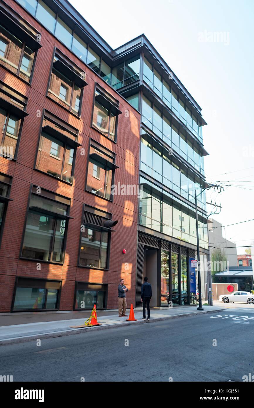 Due uomini di generazione millenaria si trovano fuori 333 Brannan, sede della società di tecnologia di gestione file Dropbox nel quartiere South of Market (SoMa) di San Francisco, California, 13 ottobre 2017. Soma è nota per avere una delle più alte concentrazioni di aziende tecnologiche e startup di qualsiasi regione in tutto il mondo. () Foto Stock
