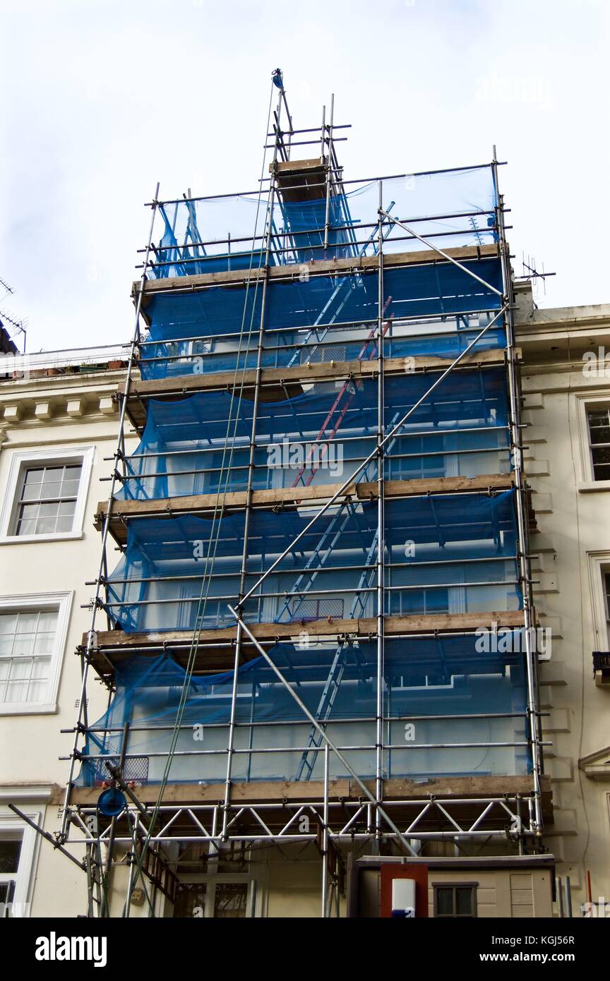 Cinque impianti di risalita del ponteggio con rete di sicurezza e il blocco e il paranco sulla townhouse, Eccleston Square, Victoria, London, Regno Unito Foto Stock