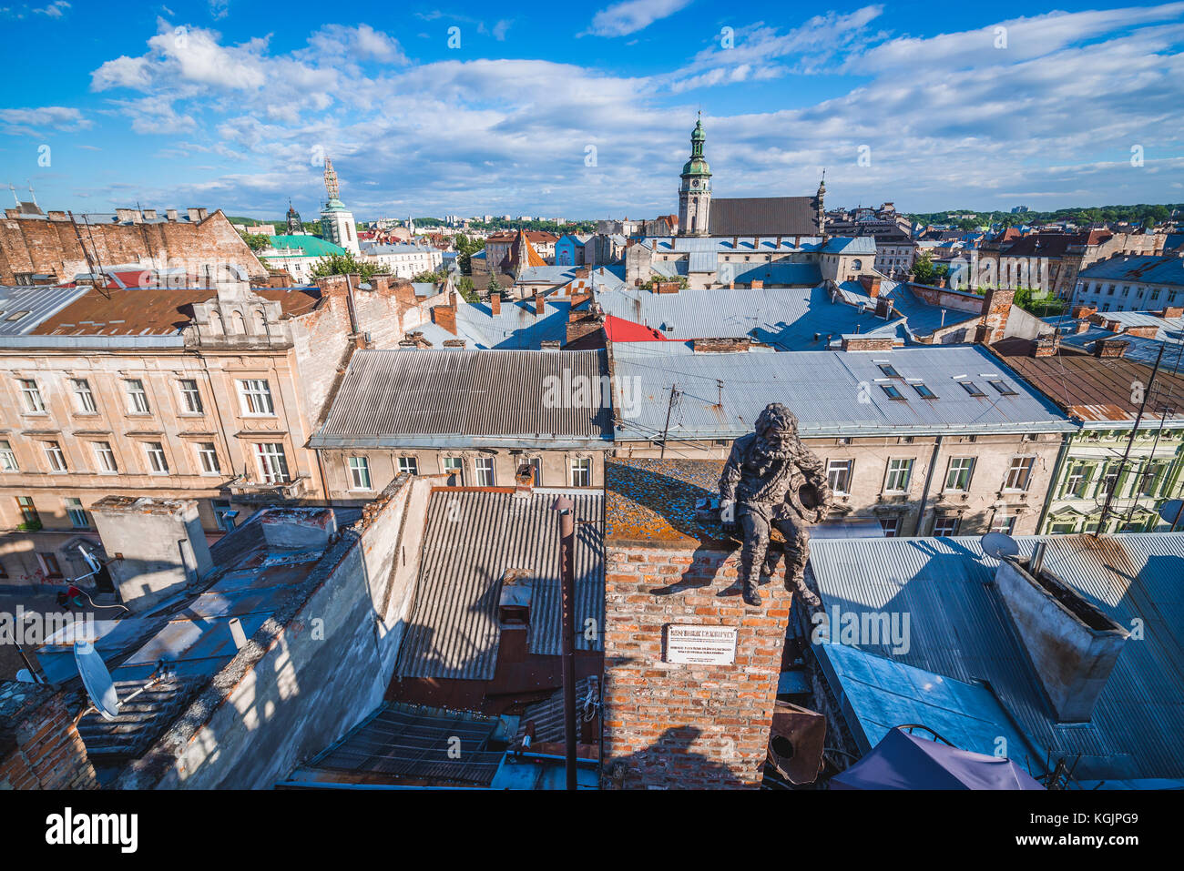 Statua spazzatrice camino sul tetto del famoso ristorante Casa delle leggende sulla città vecchia di Lviv, Ucraina. Ex chiesa Bernardina e monastero su b Foto Stock